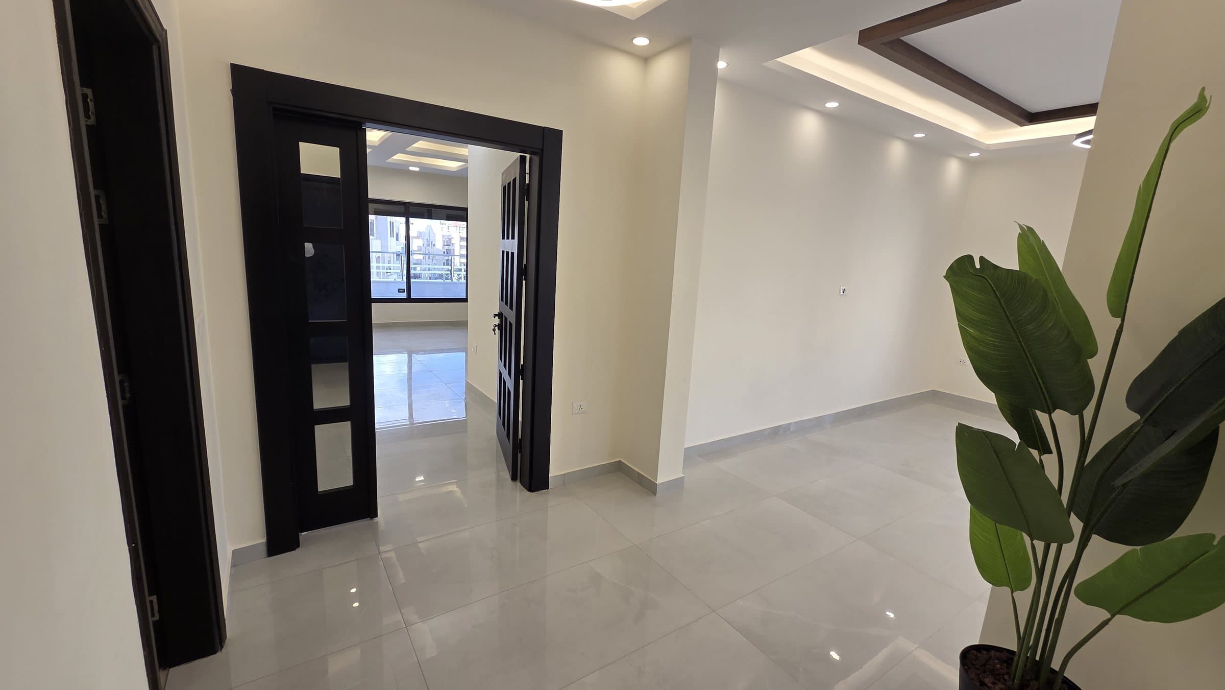 Residence 201 — Entrance showing left guest bath and powder room and on right the dining and guests salon and front the family room and kitchen