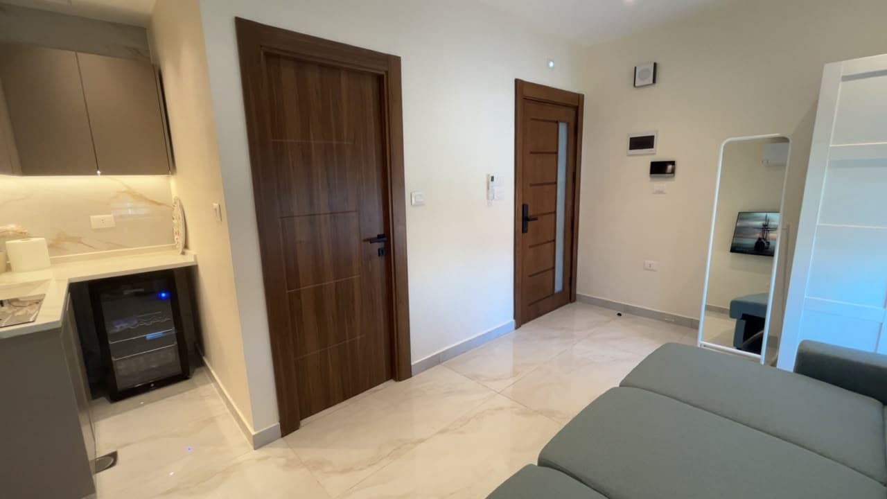 Residence 303 entry with walnut doors, video intercom, and marble flooring